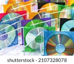 colorful compact discs in boxes stacked in a pile as background