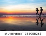 two runners on the beach, silhouette of people jogging at sunset, healthy lifestyle background with copyspace