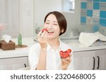 Asian woman eating strawberries in dining room