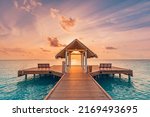 Amazing sunset landscape. Picturesque summer sunset in Maldives. Luxury resort villas seascape with soft led lights under colorful sky. Dream sunset over tropical sea, fantastic nature scenery

