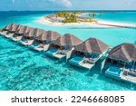 Nice tranquil Maldives island, luxury over water villas resort aerial view. Beautiful sunny sky. Sea bay lagoon beach background. Summer vacation holiday. Paradise shore exotic landscape pristine blue