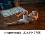 Endurance workout. Strong muscular man pumps abdominal muscles at home interior Caucasian athlete do morning workout indoor raises legs training abs muscle 