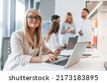 Woman working by using laptop. Group of professional business people is in the office.