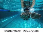 Athletic swimmer training on her own in the swimming pool at the leisure centre