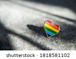 Badge heart lgbt colors lies on the asphalt. Support lesbian and gay concept background.