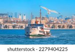 Sea voyage with old ferry (steamboat) on the Bosporus - Dolmabahce palace coastal cityscape with modern buildings under cloudy sky - Istanbul, Turkey 