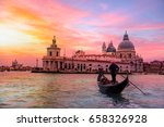 Venetian gondolier punting gondola through green canal waters of Venice Italy