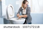 Small photo of Portrait of squeamish woman cleaning toilet with brush
