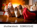 Closeup photo of family feet in wool socks at fireplace