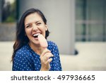 A Young Woman Eating Ice Cream And Smiling