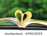Book on Table in Garden With Golden Pages Forming Heart Shape