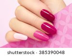 Multicolored manicure with different shades of pink nail Polish on women's hand.