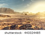Desert Landscape of Wadi Rum in Jordan, with a sunset, stones, bushes and the sky.