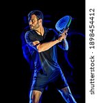 Small photo of one caucasian Paddle tennis player man studio shot isolated on black background with light painting blur effect