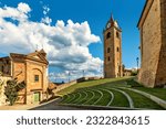 Small photo of Small church, belfry and open air amphitheater under blue sky with white clouds in small town of Monforte d'Alba, Italy.