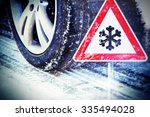 Time for winter tires - tire in winter with traffic sign
