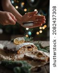 Small photo of christmas stollen powdering through a sieve cooking and decorating female hands