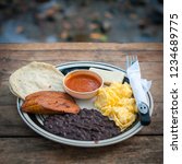 Small photo of Semuc Champey / Guatemala - April 30, 2016: Typical Guatemalan breakfast consisting of beans, eggs, tortillas and plantains that comprise the so called Desayuno Chapin. In Semuc Champey, Guatemala.