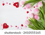Wooden white background with pink tulips and hearts, copy space for text for the holiday Valentine's Day