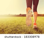  an athletic pair of legs on grass during sunrise or sunset - done with a soft vintage instagram  like filter