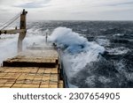 Cargo vessel with deck cargo at stormy sea. View from navigational bridge. Stormy sea, Bad weather. Gale. Rough sea.