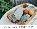 Hand-knitted woolen socks of different colors in a wicker basket on a coffee table close-up