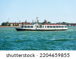 Empty white ferry or vaporetto in motion in the Venetian Lagoon on a sunny spring day. Venice, UNESCO world heritage site, Veneto, Italy, southern Europe.