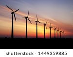 Wind turbines farm at beautiful orange sunset.