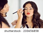 Young beautiful asian woman applying make-up by make-up artist