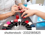 Small photo of Woman getting professional manicure in beauty salon, master applies gel polish on nails and dry in a uv lamp, nail extension tools