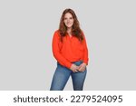 Attractive smiling curvy woman in red silk blouse posing on white background