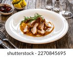 Small photo of Fried veal loin in chanterelle mushrooms sauce on wooden table