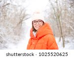 Close-up portrait shot a happy woman wearing hat and warm coat while standing outdoor and enjoy winter weather. 