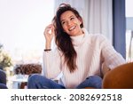 Shot of attractive woman wearing casual clothes while relaxing in the armchair at home.