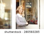 Portrait of designer woman standing in front of small vintage store. Small business.