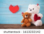 Teddy bear with red heart on old wooden background. Valentine's day concept
