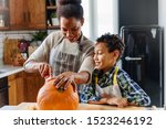 Mother and son carving pumpkin making Jack-o-Lantern
