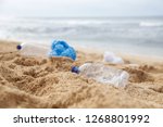 Plastic trash at the sandy beach. Plastic pollution concept. Single-use plastic is a human addiction that is destroying our planet and impacts our waters, sea life and humans.