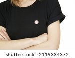 Small button badge pinned onto black shirt	