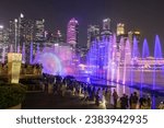 Small photo of Marina Bay, Singapore - ‎‎October 12, 2023: people sightseeing Spectra show of dance fountains, light and water show along promenade by Marina Bay Sands with Central business district modern building.