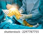 Small photo of Doctor or surgeon in blue gown used robotic navigator total knee joint arthroplasty surgical instrument for surgery inside operating room.Medical technology in orthopedic surgery.Hand of people.