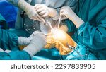 Small photo of Doctor or surgeon in blue gown used robotic navigator total knee joint arthroplasty surgical instrument inside operating room.Medical technology in orthopedic surgery.Hand of people with a saw.