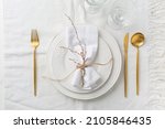 Place setting in white - plates, cutlery in gold, napkin 
