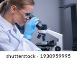 Small photo of Professional female scientist is working on a vaccine in a scientific research laboratory. Genetic engineer workplace. Technology and science concept.