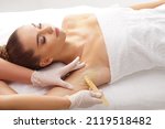 Small photo of Beautician is removing hair from young female armpits with hot wax. Woman has a beauty treament procedure. Depilation, epilation, skin and health care concepts.