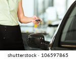 Woman standing with key next to her new bought or rental car