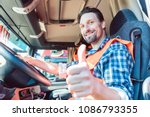 Truck driver man sitting in cabin giving thumbs-up 