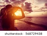 Tourist woman watching sunset at tropical ocean beach