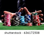 Gambler man hands pushing large stack of colored poker chips across gaming table for betting
