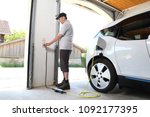 A Man Charging Electric car  at outlet at home
